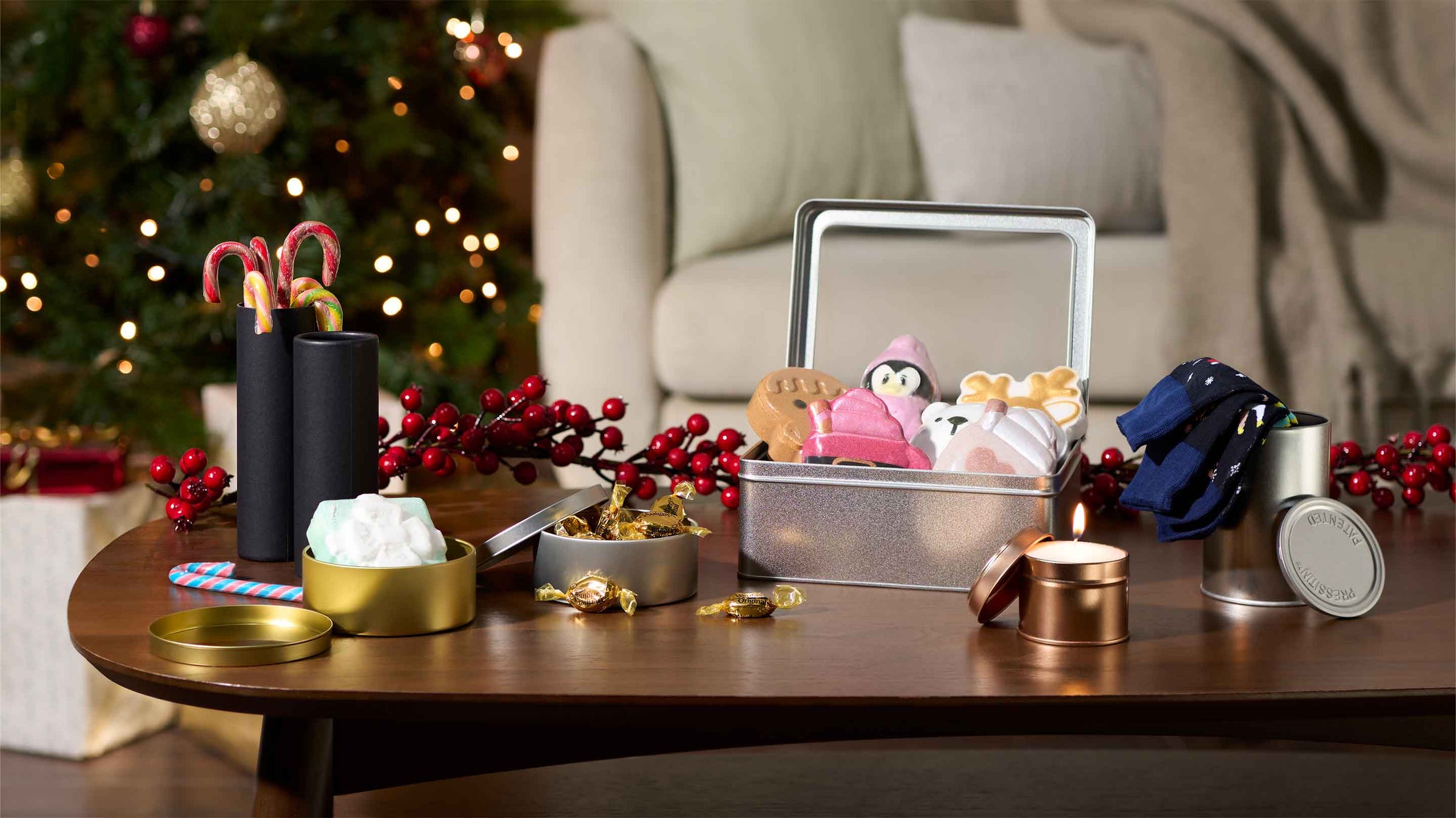 Decorative packaging on a table with a Christmas tree and sofa in the background